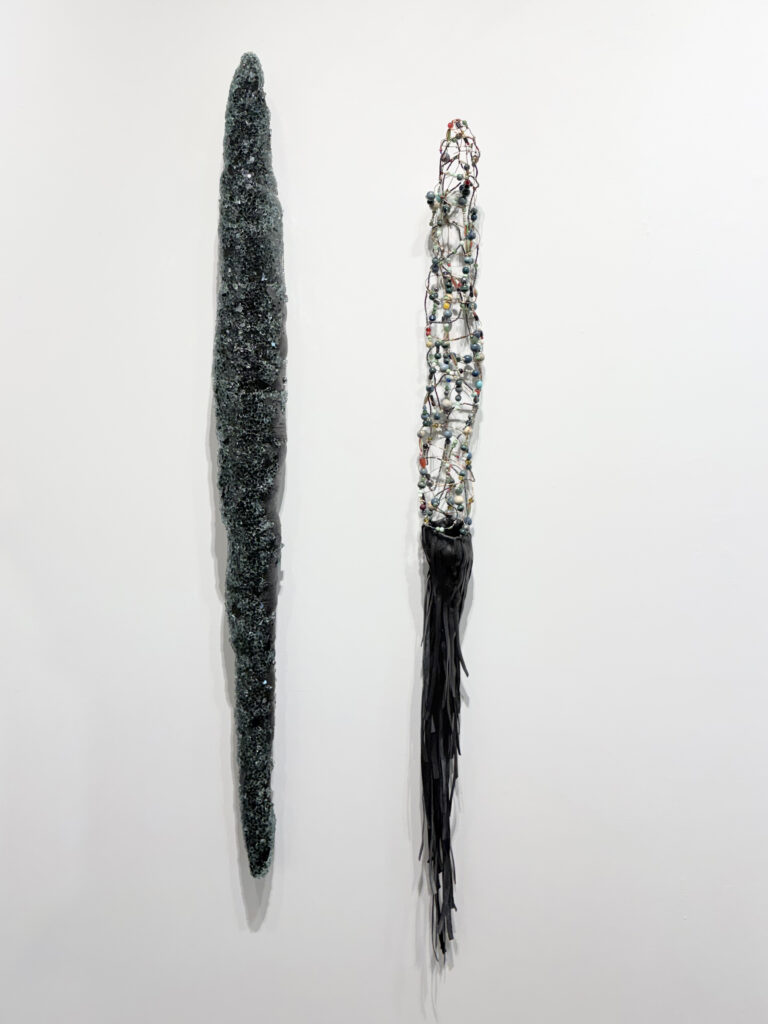 L'Ombre du corps, 2026. Galerie Le Trécarré, N-É. Photo C Patenaude // 2026. Vitre de pare-brise, bourrure, bois. 120 x 11 x 10 cm. // 2026. Chambre à air, billes, fil de cuivre. 115 x 9 x 10 cm.